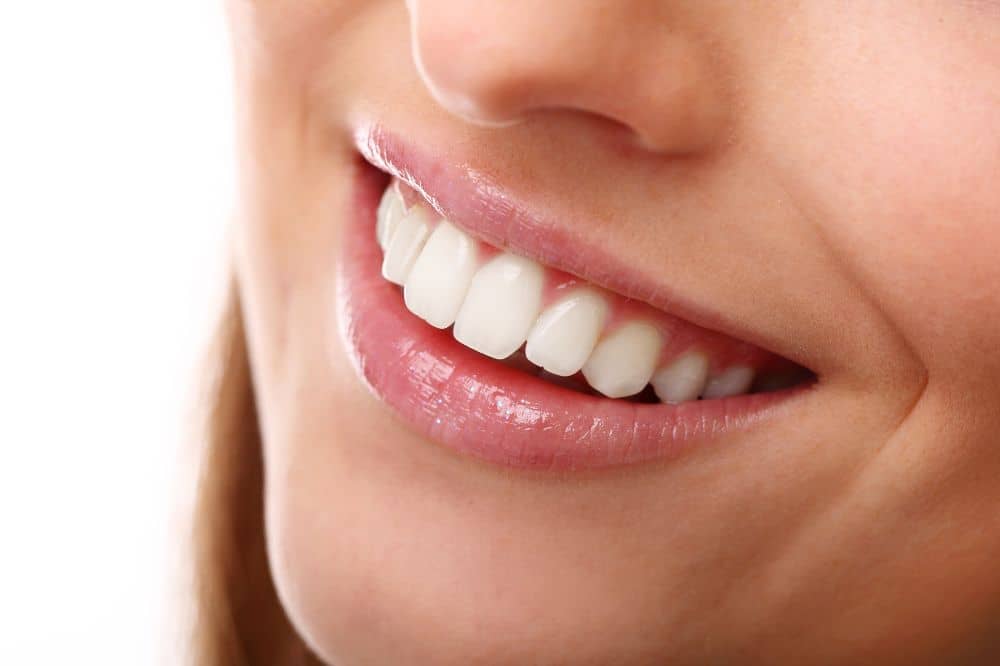 a girl is smiling and showing her teeth