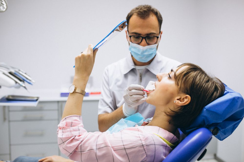 a lady is checking her teeth after a dental filling treatment