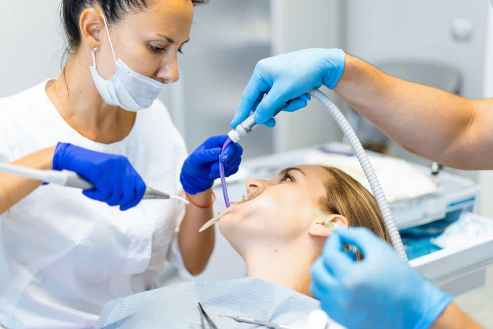 A dentist examines a woman's teeth