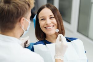 a lady is smiling after getting dental veneers treatment
